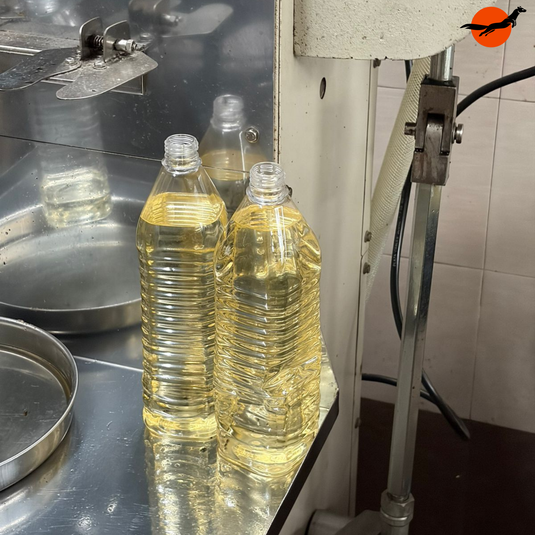 Freshly pressed Kuttiyadi coconut oil being bottled at the rotary mill, traditional unrefined coconut oil